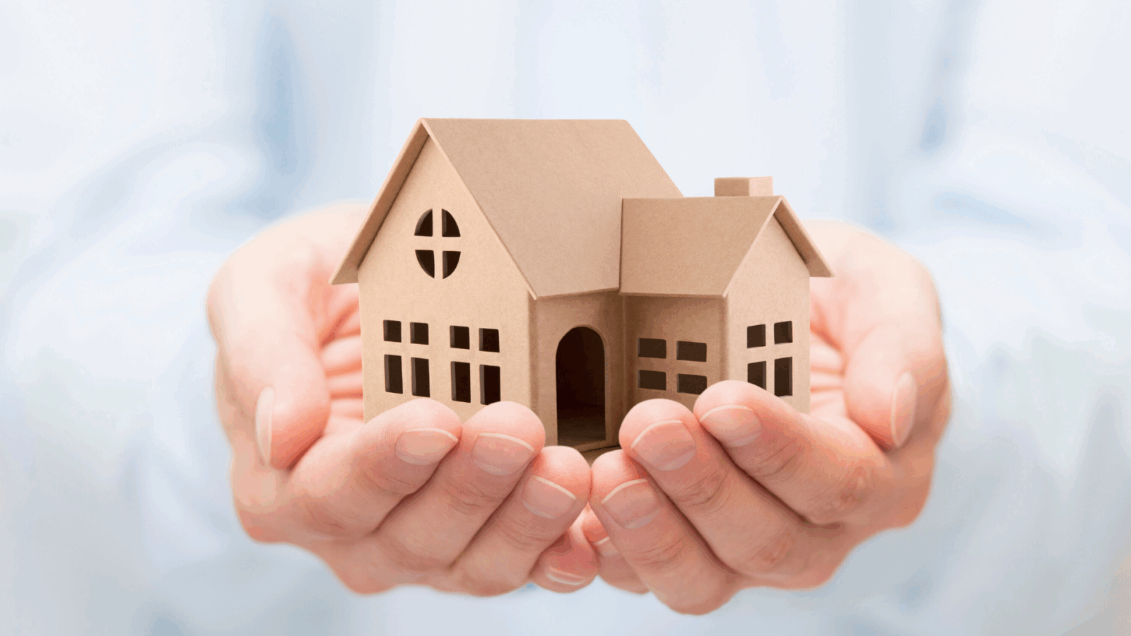 An image of a small business owner in North York holding a cardboard cutout of an estate in their hands.